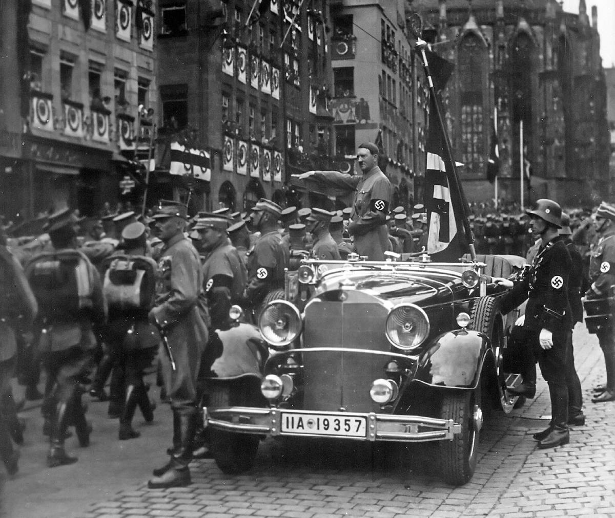 Adolf Hitler při prohlídce členů SA v roce 1935. Doprovází ho Blutfahne a její nositel SS-Sturmbannführer Jakob Grimminger.